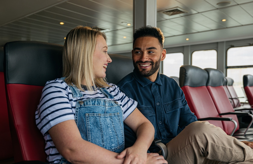 a smiling couple sitting onboard ferry