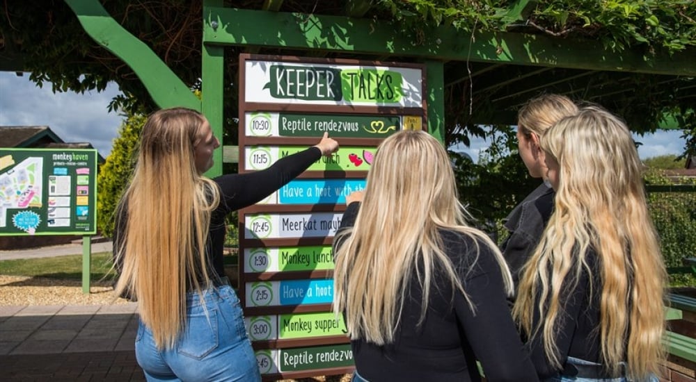 Visitors looking at the Keeper talks schedule sign